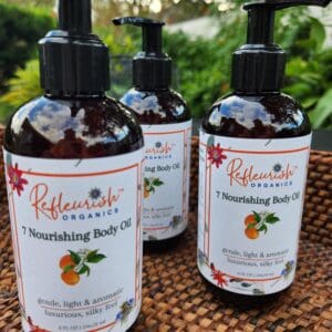 Three bottles of body oil sitting on a table.